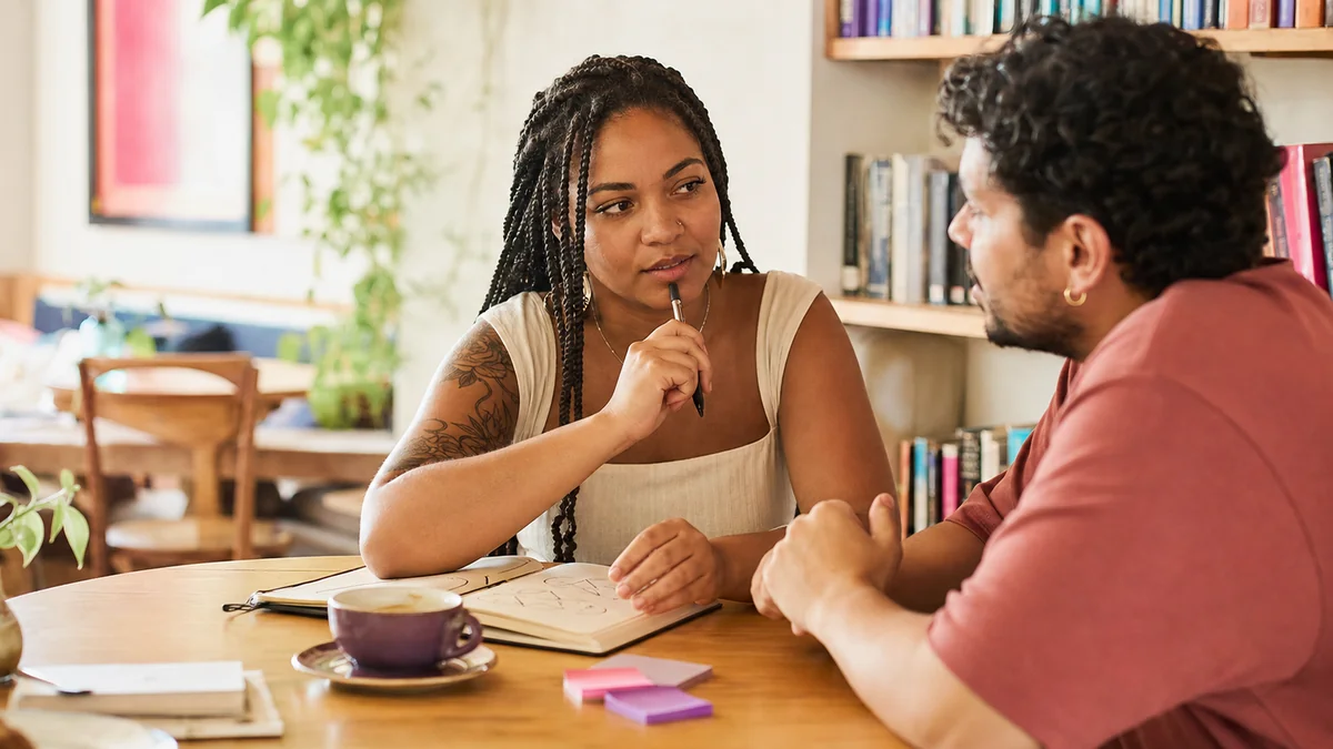 Mulher brasileira adulta conversando sobre valores e prioridades em um café.